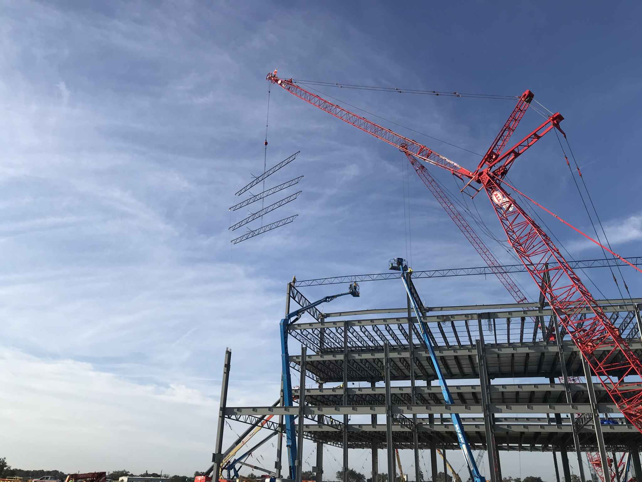 Bowman Steel crane lifting steel beams against dramatic sky